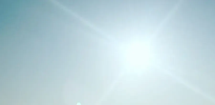 Soleil perçant le ciel bleu au-dessu de la ville