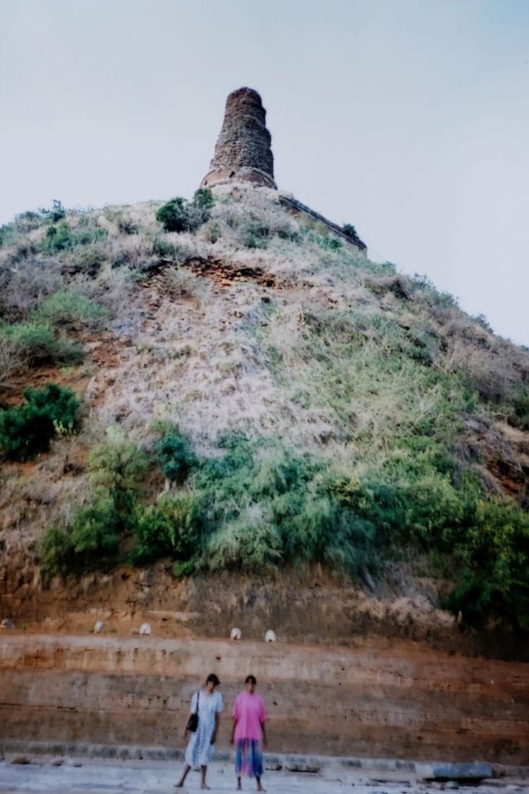 The author and her sister stand in front of an eight story or more stupa (before its restoration) in Sri Lanka.