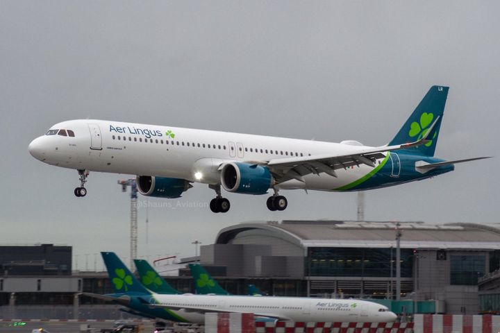 An Aer Lingus Airbus A321XLR aircraft landing at Dublin Airport, with another Aer Lingus plane visible in the background on the tarmac