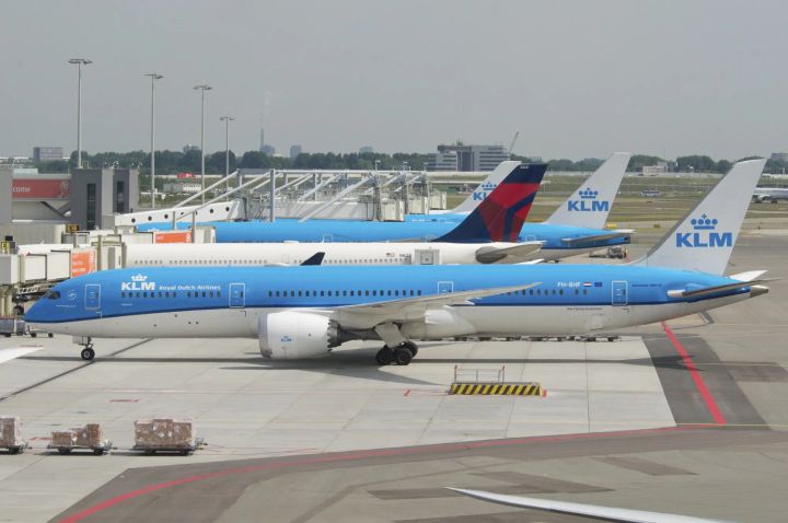 KLM Boeing 787 Dreamliner parked at Amsterdam Schiphol Airport alongside Delta and other KLM aircraft.