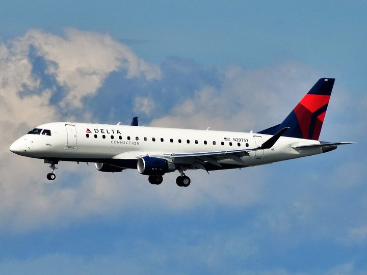 A picture featuring Delta Connection jet flying in midst of clouds