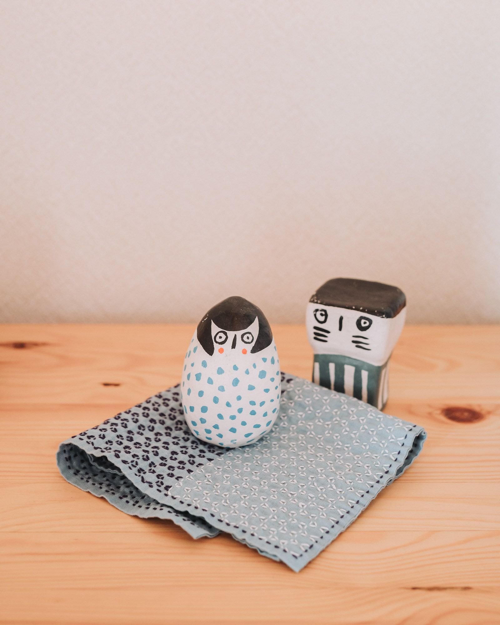 Kagome sashiko pattern dish cloth with figurines on a wooden board.