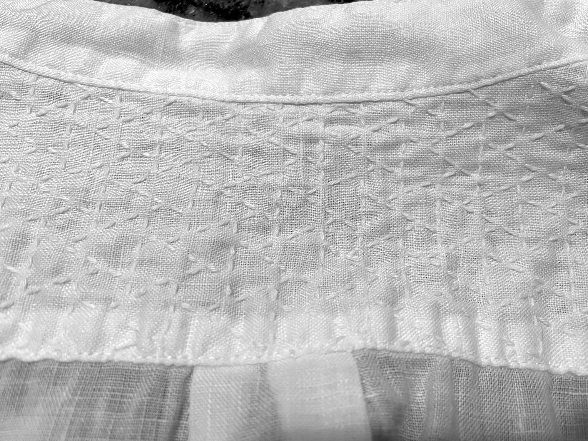 Musubikikkō sashiko pattern stitched in white sashiko thread on a white linen shirt