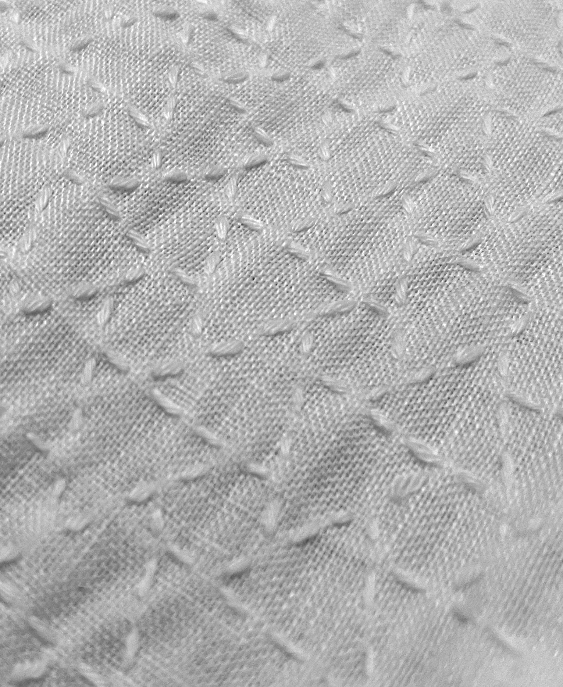 Musubikikkō sashiko pattern stitched in white sashiko thread on white linen close up
