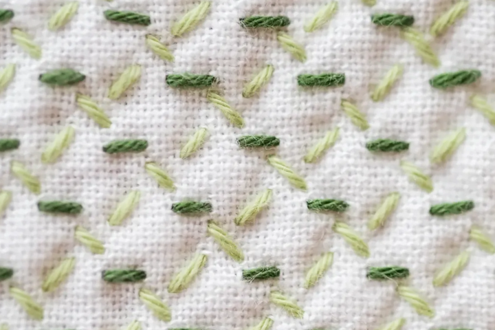 Sashiko Pattern Hitomekagome in two shades of green on white fabric