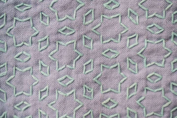 Sashiko pattern "hoshi to mitsubishi" in pale mint green thread on mauve fabric.