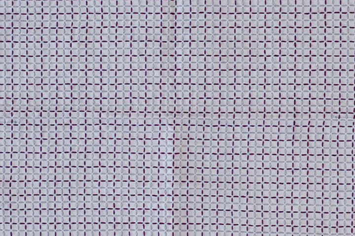 The sashiko pattern kōshi in violet and light blue thread on white fabric.