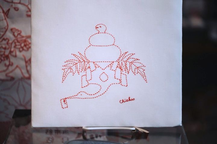 Sashiko that shows a crane with a snake doubling as a ricecake on top, serving as new year decoration.