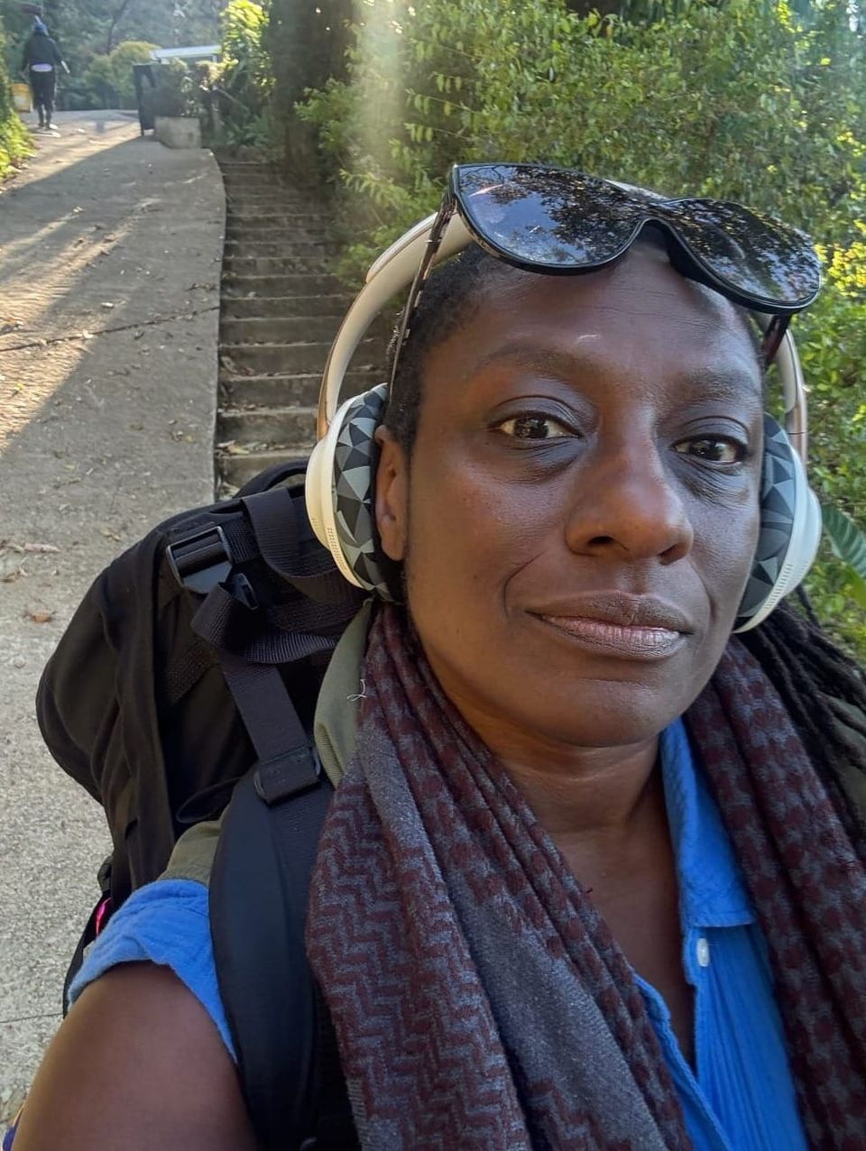 Atena walking down the mountain, above Antigua, Guatemala,wearing a blue dress and her Black-on-Black kuffiyah.