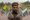 A man holding the flags of Pakistan and Azad Kashmir.