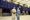 Two men dressed in salwar kurta with their hands behind their backs looking up at trading screens at the Pakistan stock excha