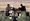 Five local journalists wait on the wreckage of a minibus while reporting on an uprising of Taliban prisoners in Pul-e-Charkhi