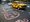 A yellow taxi drives along a street in Kolkata decorated with colourful Bengali messages painted on the asphalt for Internati