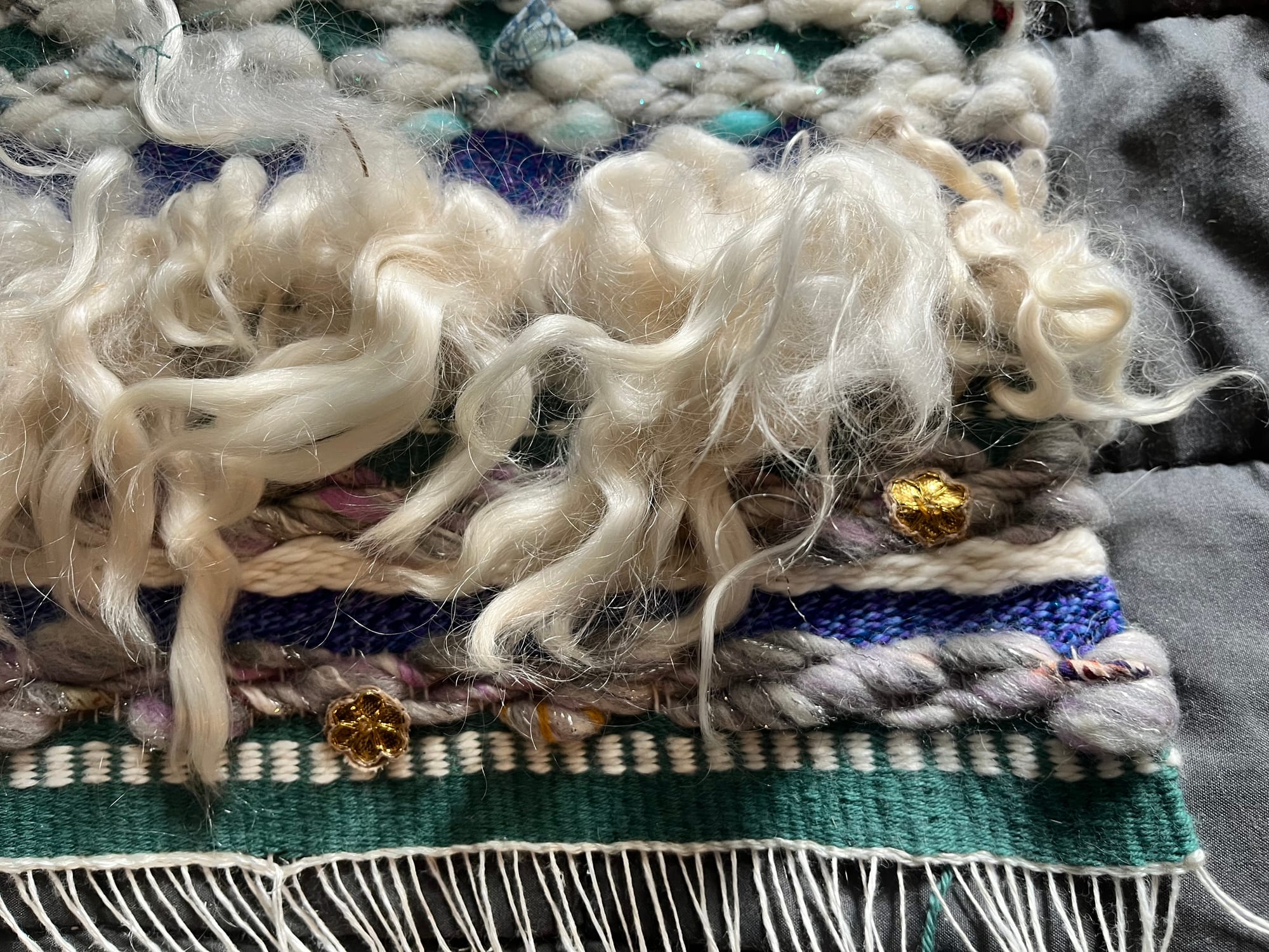 Bottom right detail of the tapestry showing several curly sheep wool locks