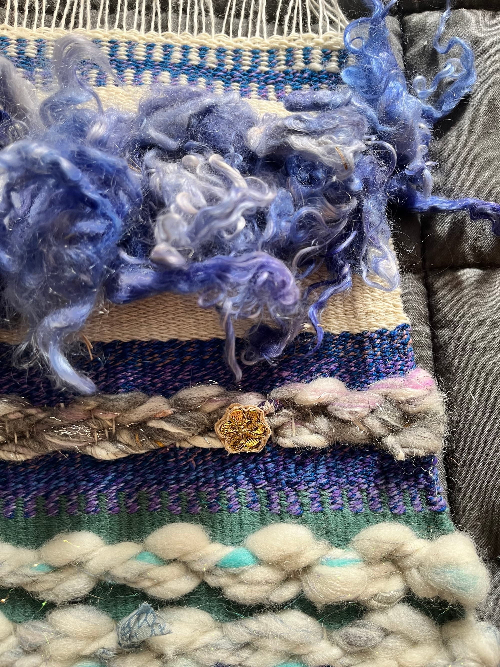 A purple, blue and white striped detail of tapestry