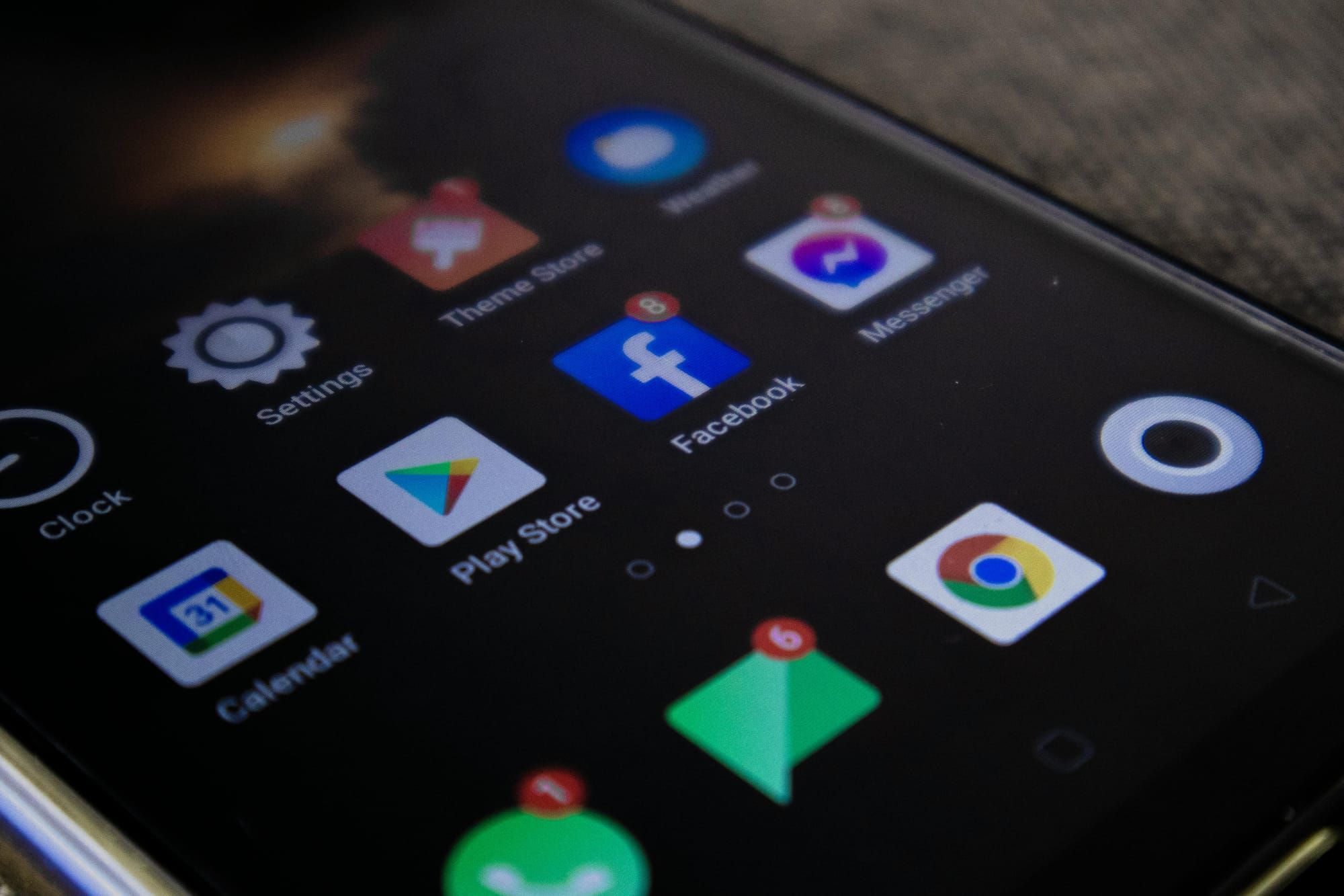 A close-up of a smartphone screen displaying app icons with several notification badges visible. 