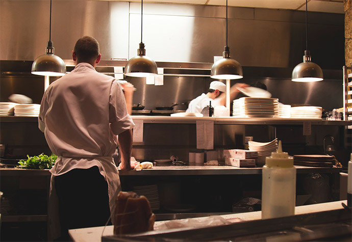 Photo of a kitchen pass-over with kitchen staff on either side