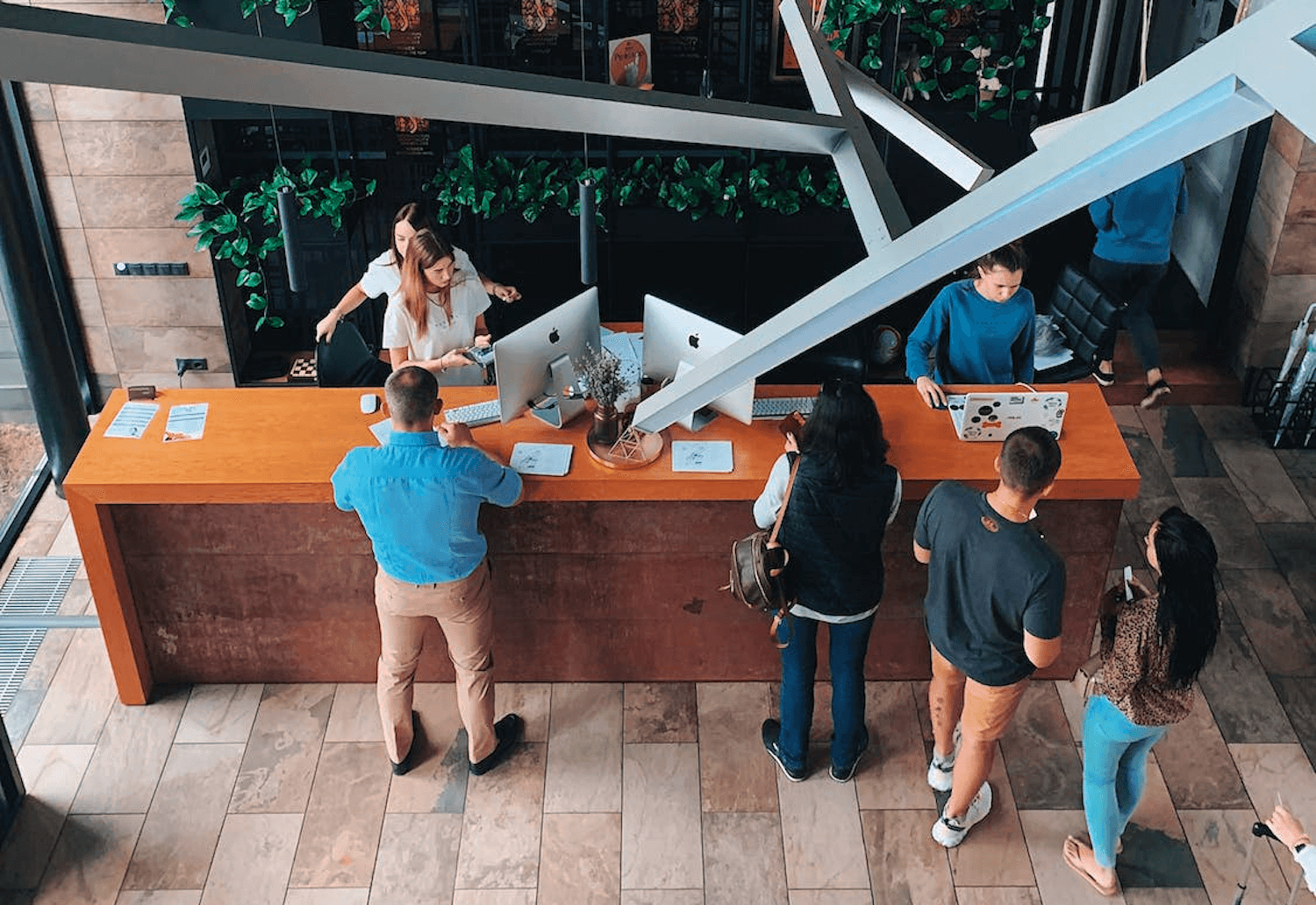 Photo of people checking in at a long hotel reception desk