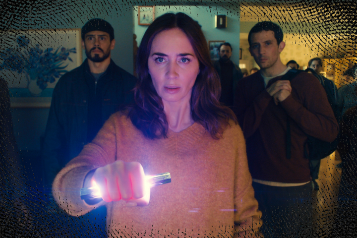 still from the movie Disclosure Day: Emily Blunt stands in front of a group of people holding a glowing metal object