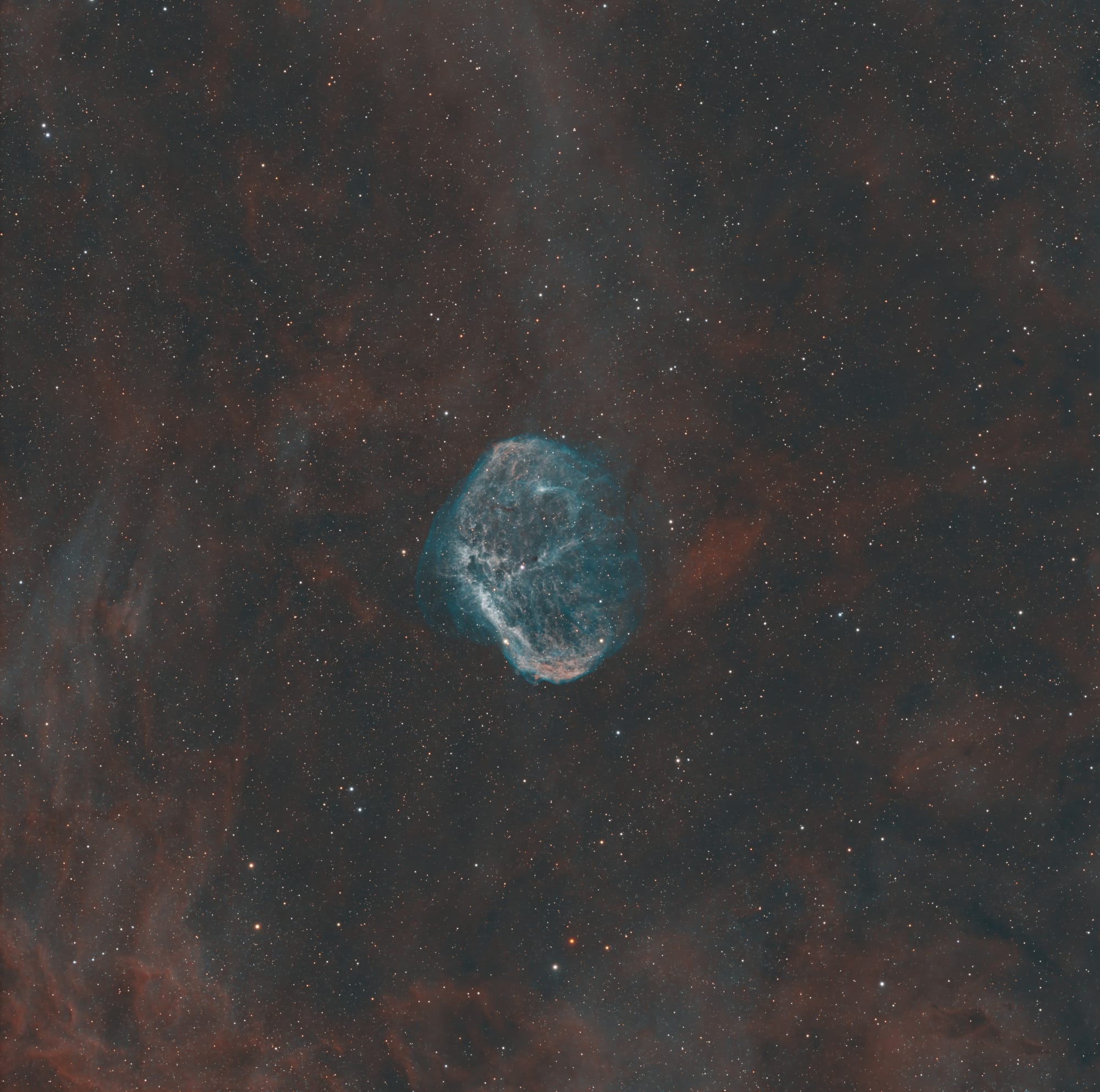 A blue, brain-shaped nebula in a cloud of red gas