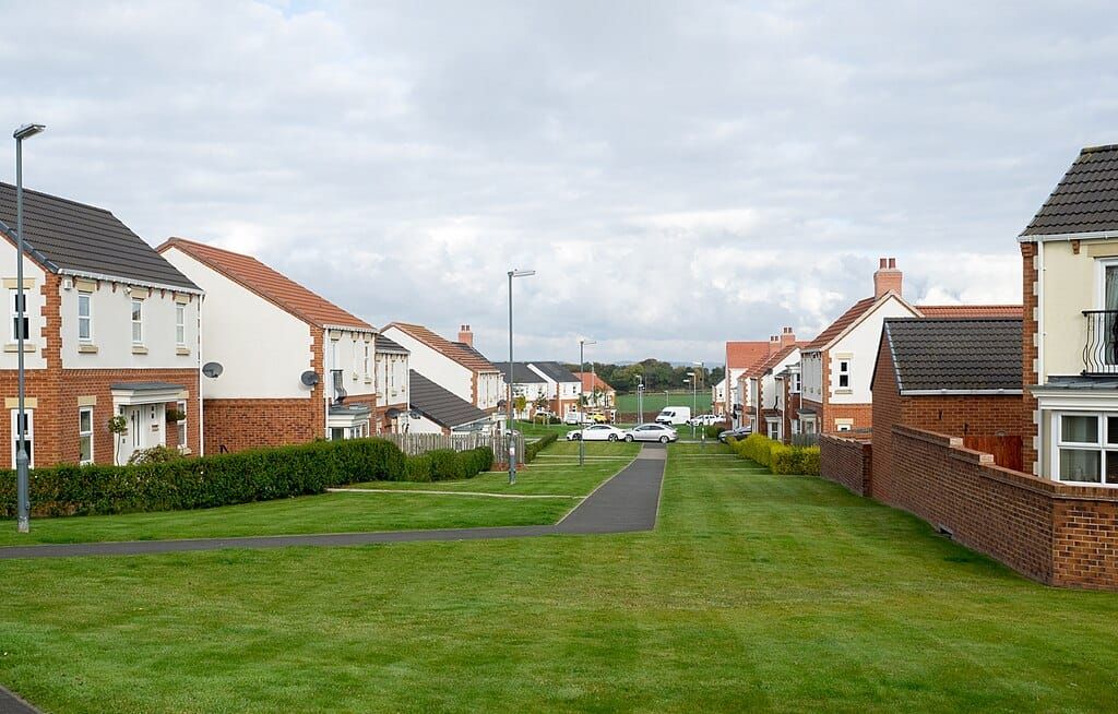 Photo of rows of semi-detached houses separated by green lawns