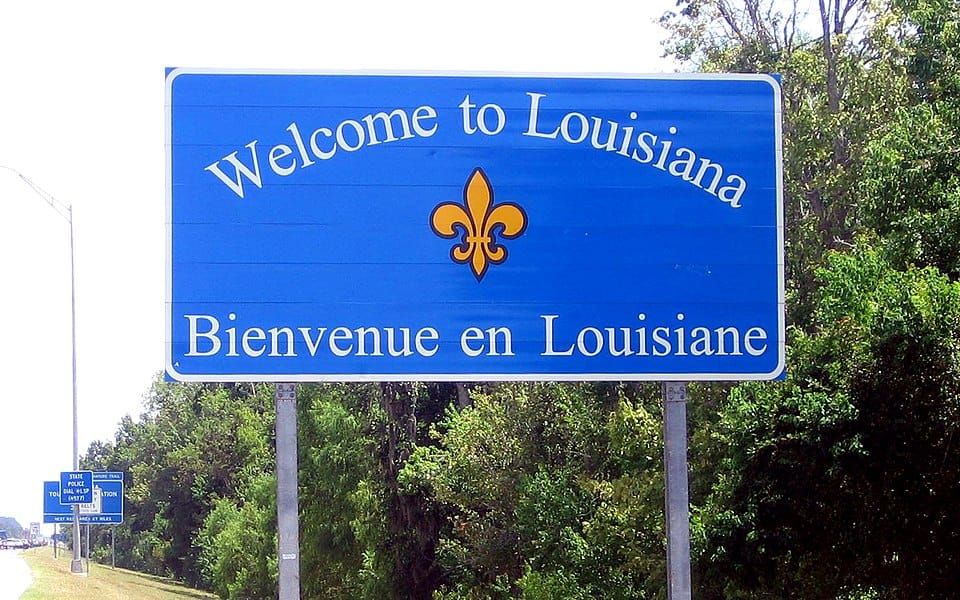 Highway sign reading “Welcome to Louisiana / Bienvenue en Louisiane” with a fleur-de-lis