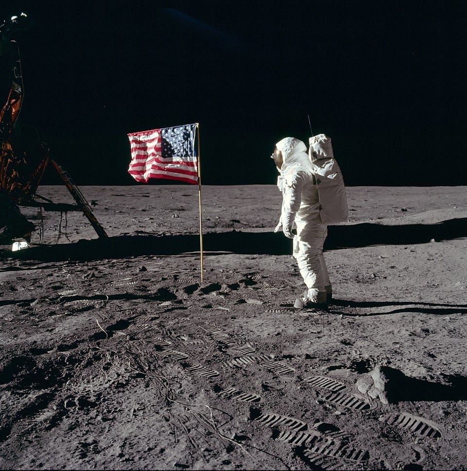 An astronaut on the moon saluting a US flag