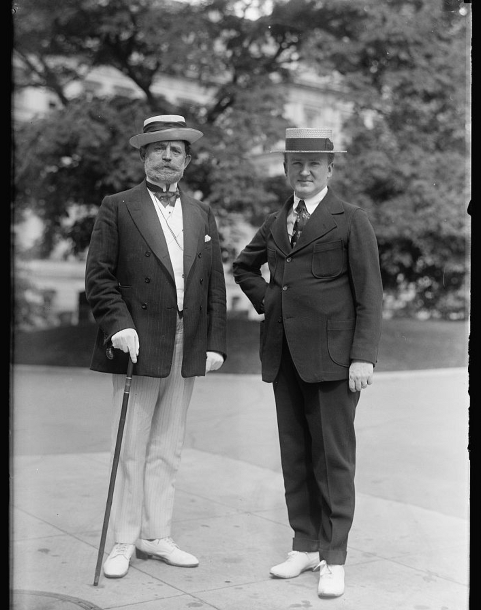 B&W photo of two men in suits, straw boaters, and white shoes