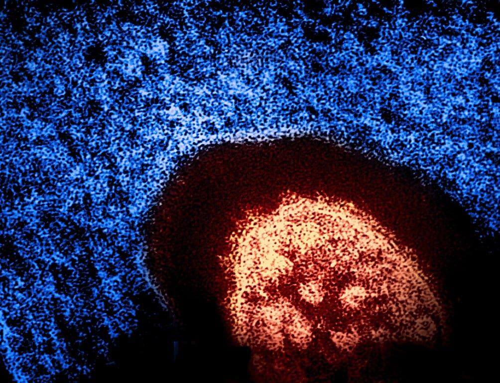 Grainy photograph of a red oval against a blue background