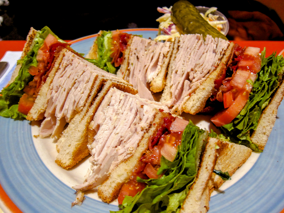 Photo of a turkey club sandwich served on a plate