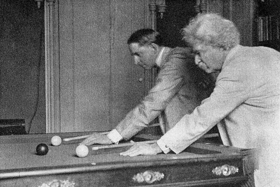 B&W photo of two men playing billiards