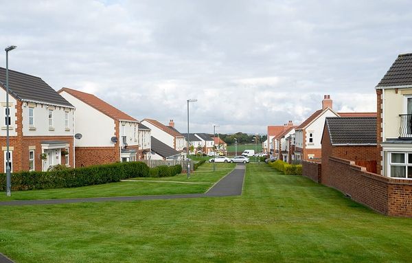 Photo of rows of semi-detached houses separated by green lawns