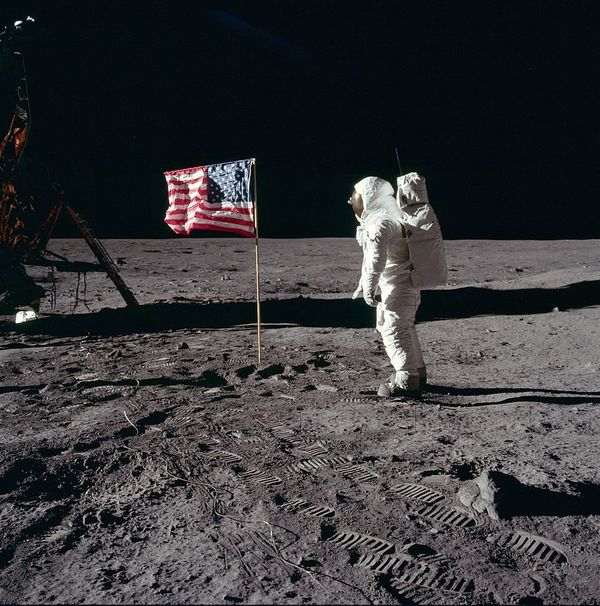 An astronaut on the moon saluting a US flag