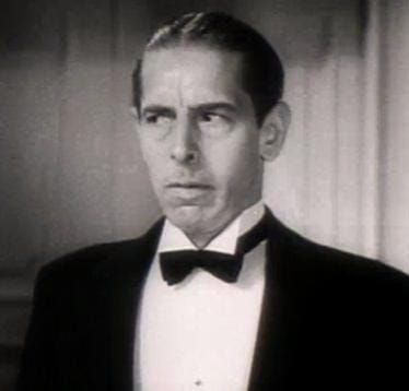 B&W headshot of a man in formal dress looking askance