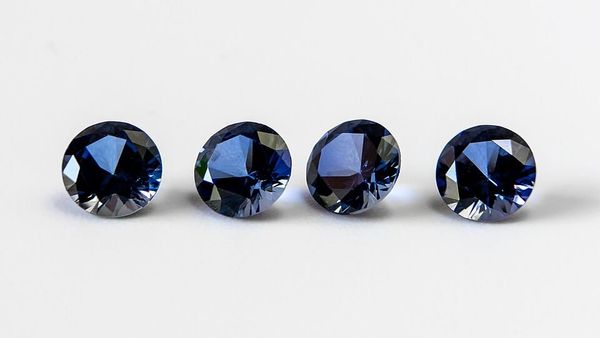 Photo of four, blue, faceted gemstones