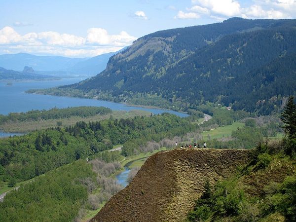 Photo of a large river flowing through a forested, mountain region