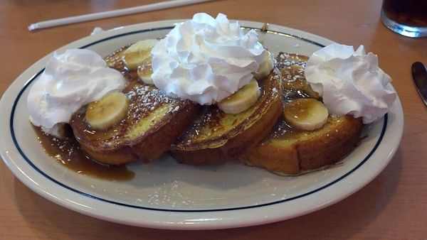 Photo of a dish of bananas Foster served over brioche French toast