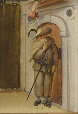 Image of a man in baggy clothing, cape, and wide-brimmed hat standing by a door having a pitcher of water poured on his head