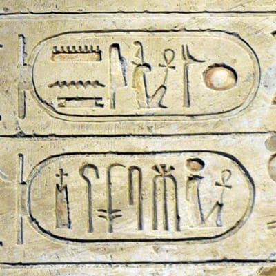 Photo of a stone engraved with two ovals containing Egyptian hieroglyphics