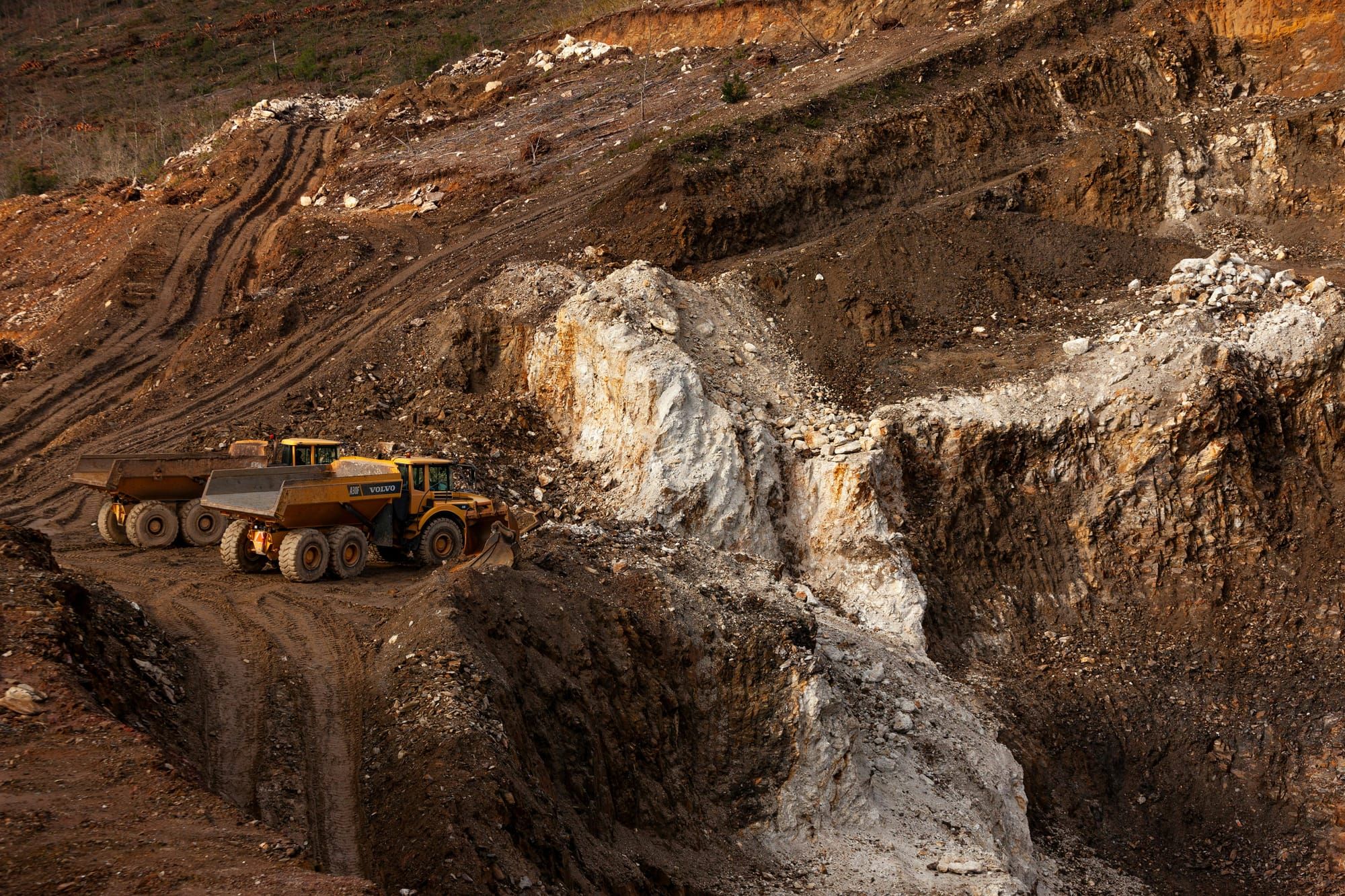 Mining trucks at an open-pit mine site, representing Omnia  mining operation