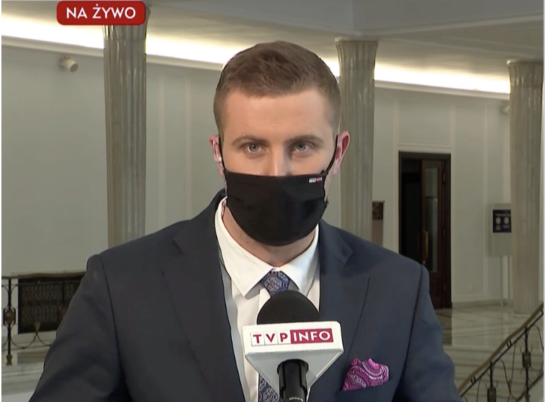 Młody wilk Kłeczek z niedźwiedziem w tle