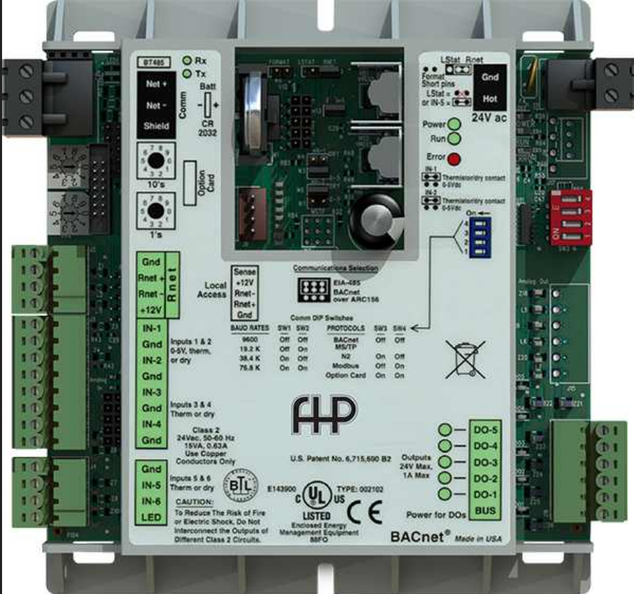 Photo of a paper-back sized digital control unit, showing circuit boar with input and output terminals along the sides and a printed cover over the centre