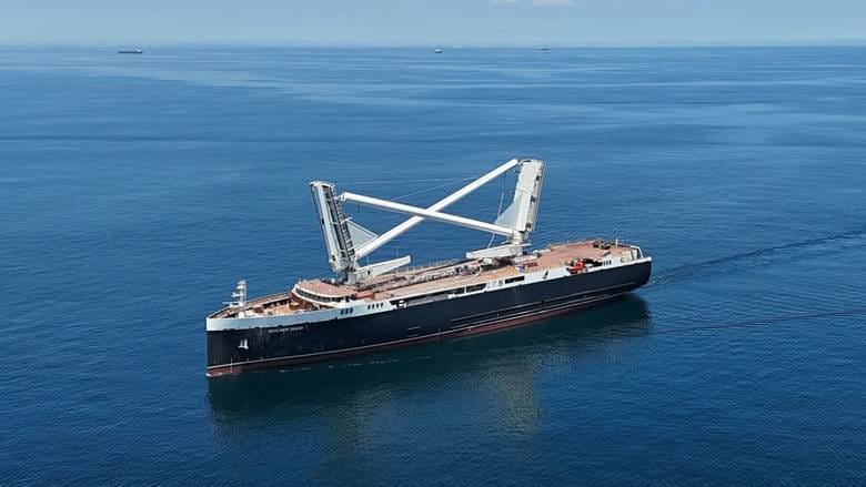 Modern hybrid sail/diesel cargo ship with its pair of sail masts lowered to allow passage under bridges. 