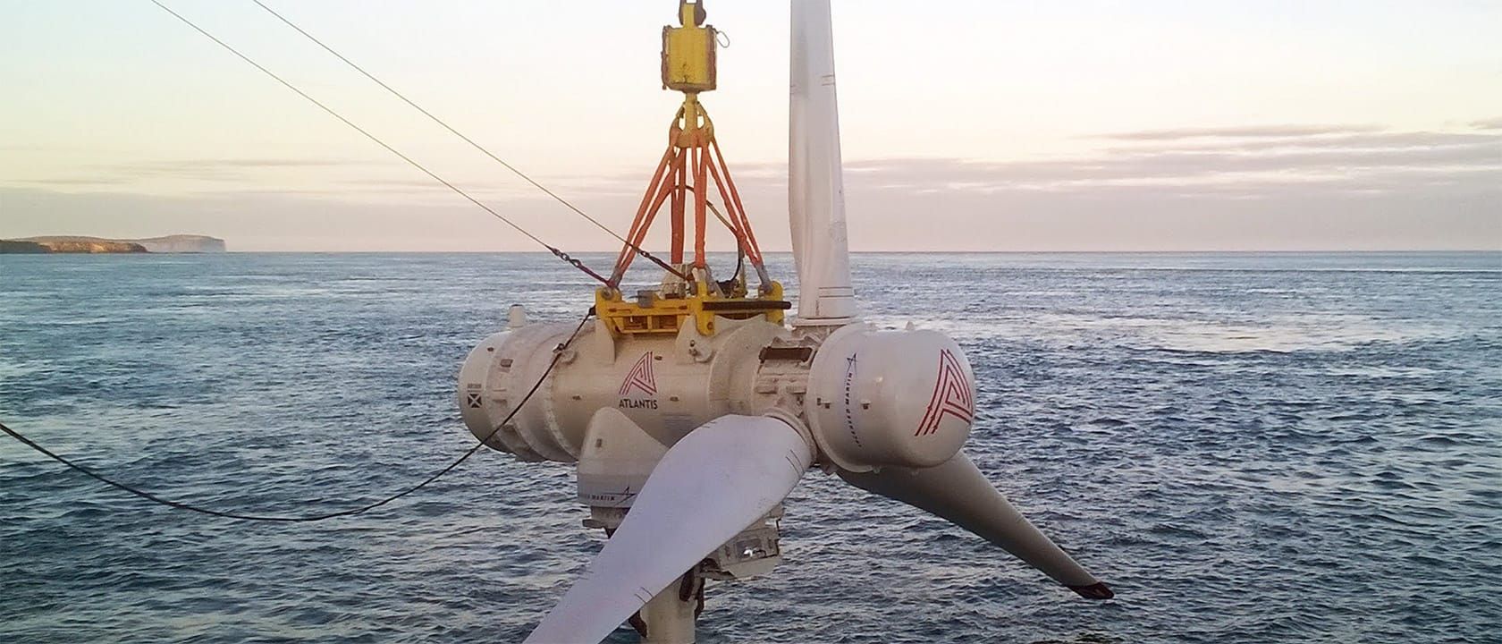 Three-bladed tidal turbine being lowered into place by a large crane into the sea off Scotland's Pentland Firth, cliffs in the background.