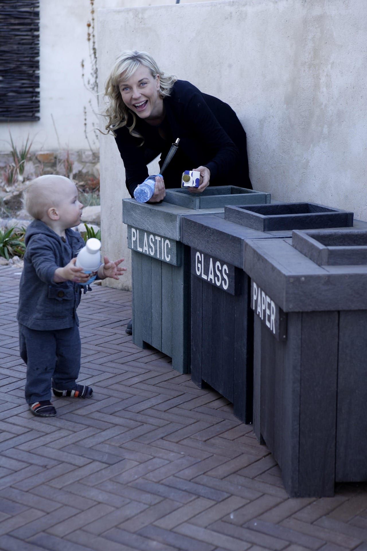 A toddler, picking up the tricks of recycling at an early age.