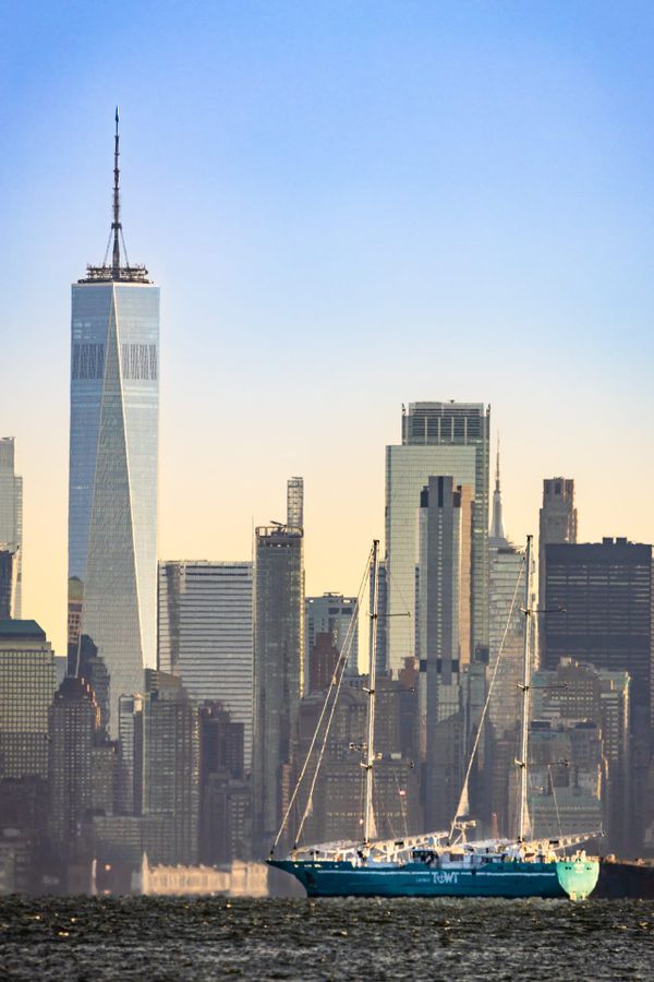 Modern two-masted commercial sailing ship in New York, with Manhattan skyline in background