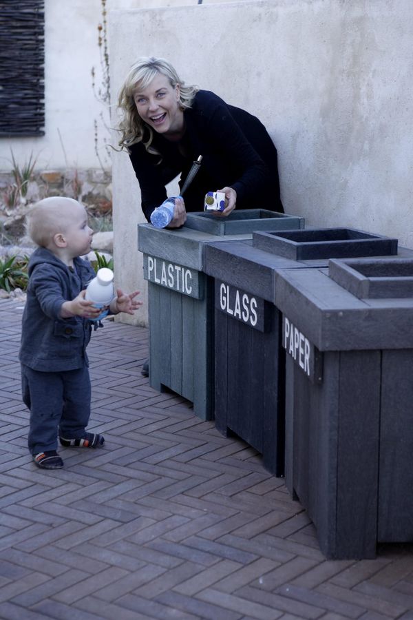 A toddler, picking up the tricks of recycling at an early age.