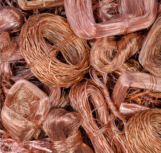 Many coiled and twisted bundles of bare, shiny copper wire, ready for recycling