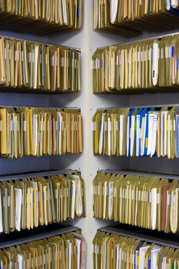 Photograph of ten racks of open hanging file folders filed with papers.