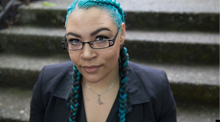 Sherae Lascelles sits on some old stone steps, looking up at the camera.
